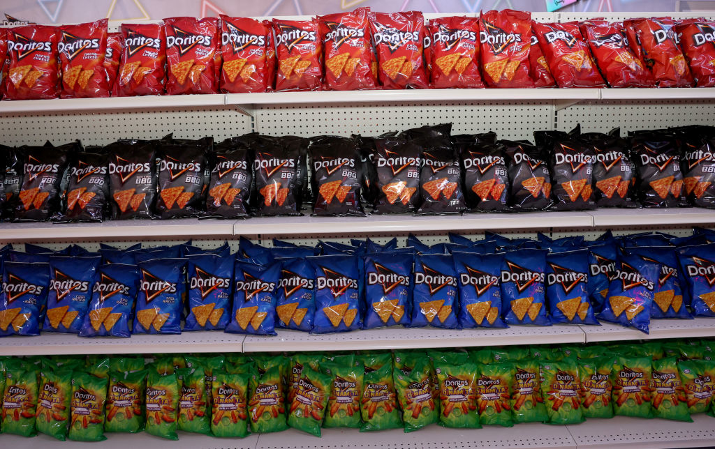 Shelves stocked with various flavors of Doritos chip bags in a store