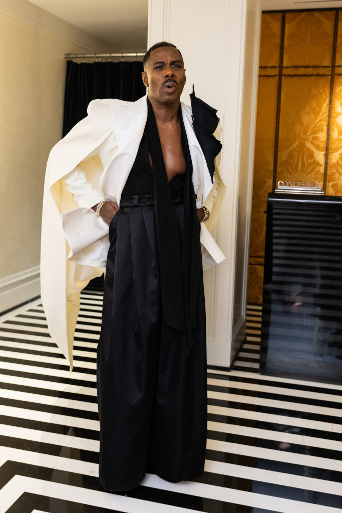 Billy Porter in a unique white jacket and black trousers, posing indoors