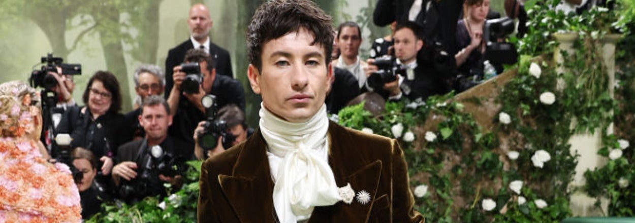 Ezra Miller in an elaborate outfit with a caption jokingly comparing them to Willy Wonka