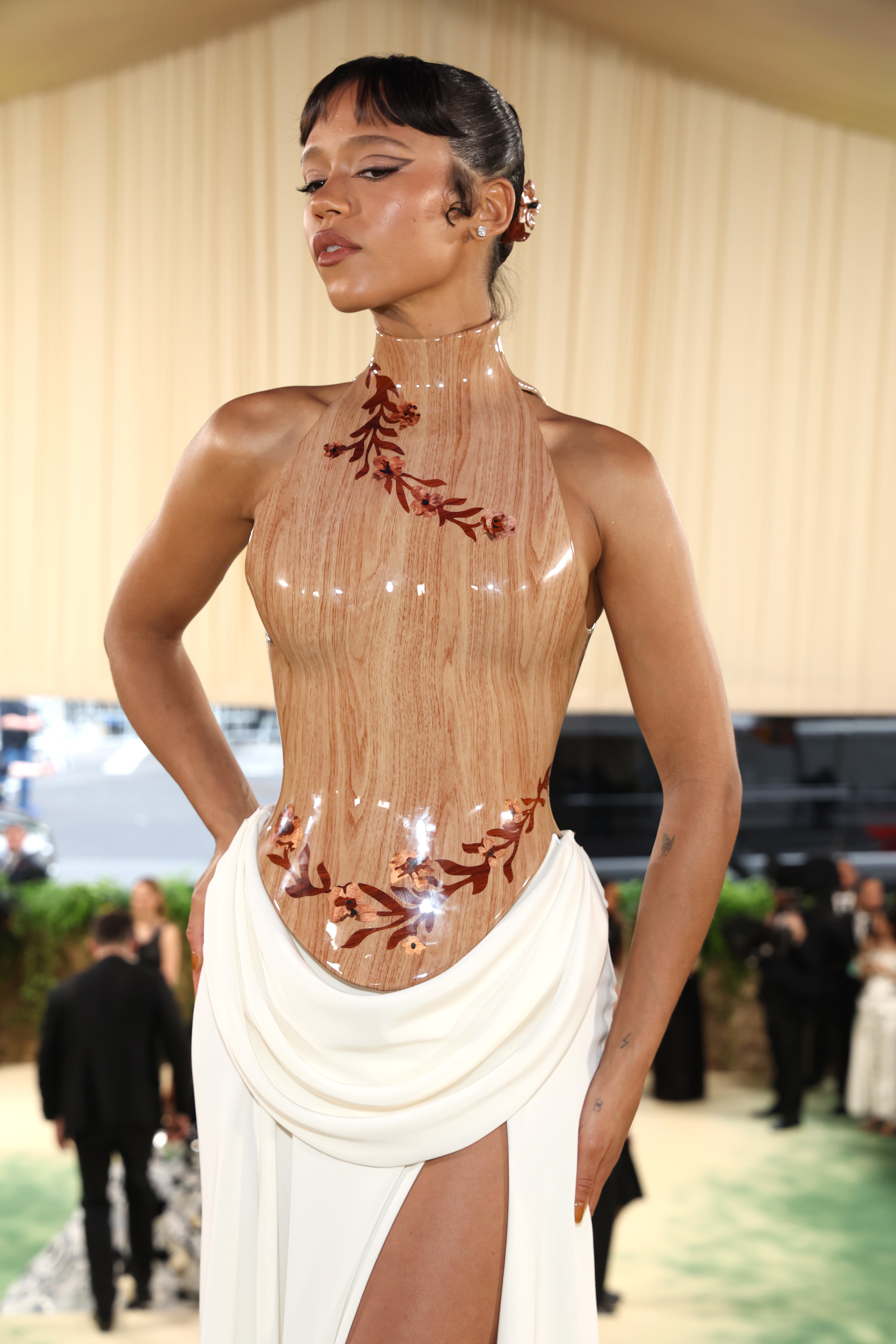 Taylor Russell in a dress with a wooden corset and white draped skirt