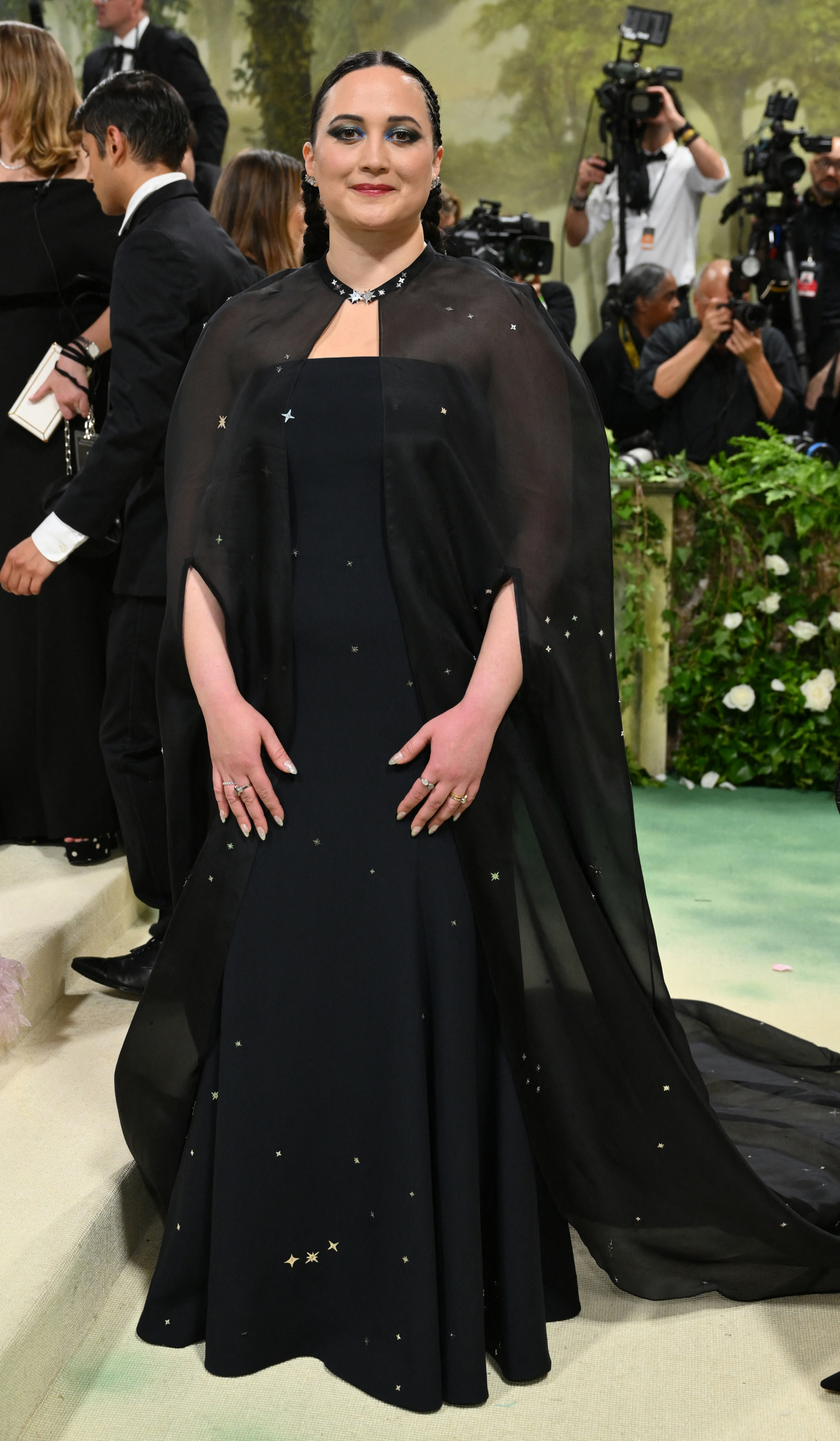 Lily Gladstone at the 2024 Met Gala wearing a floorlength gown with a flowy cape