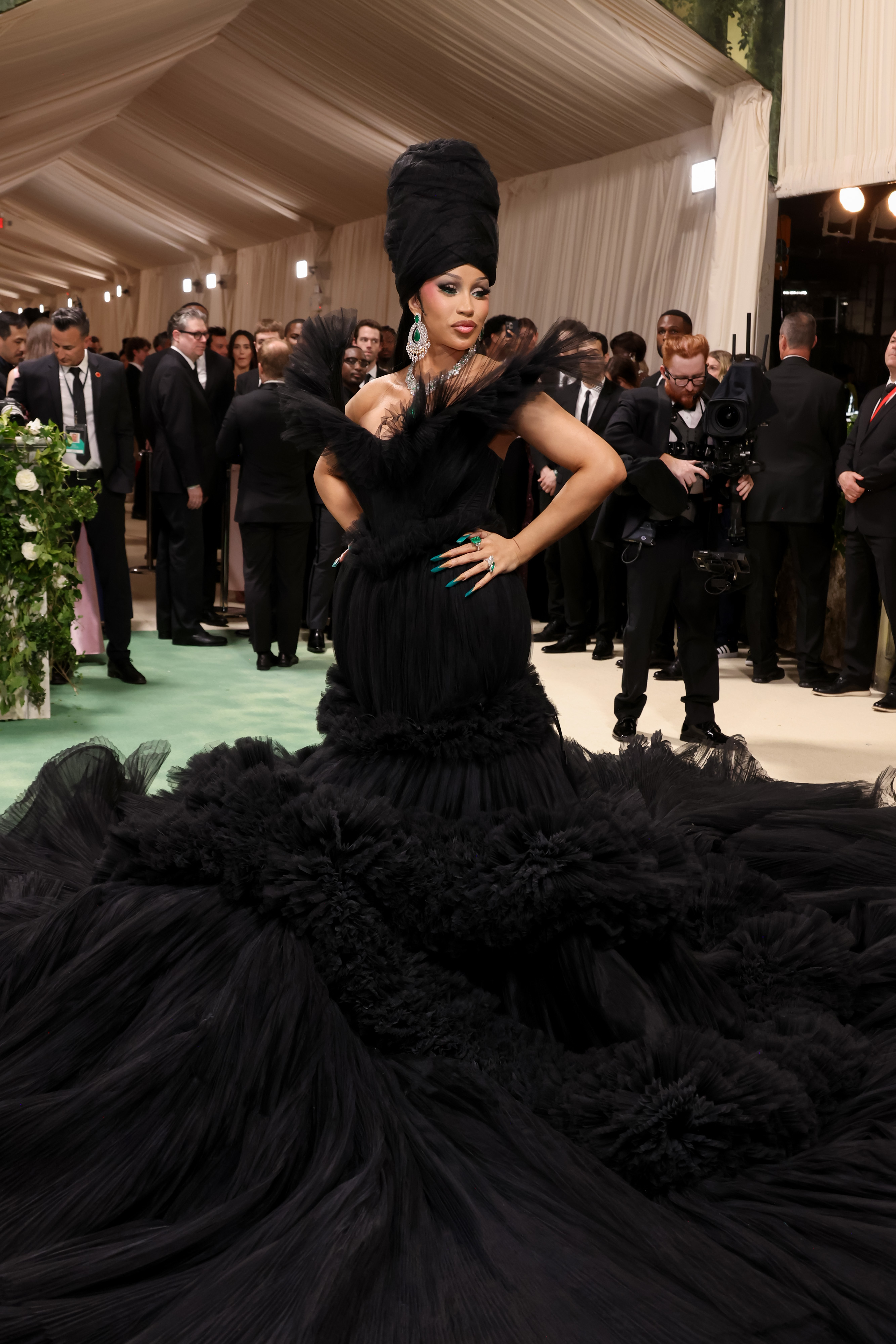 Cardi B in an extravagant black feathered gown and towering headpiece on the red carpet