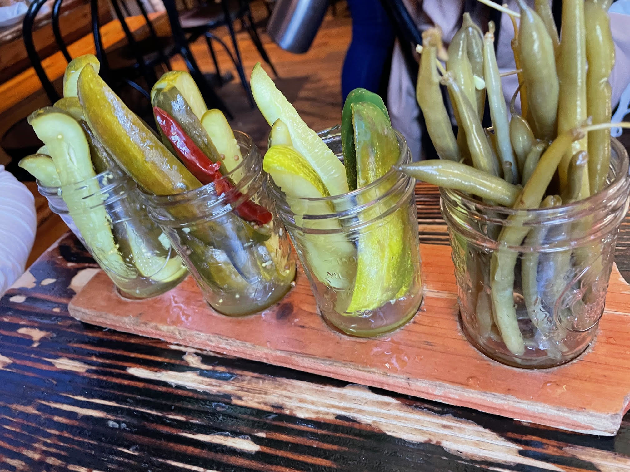 Pickles in jars on a wooden serving board