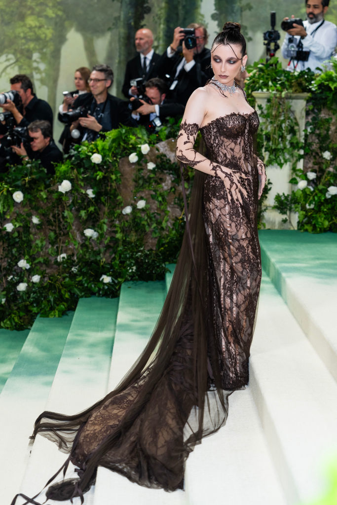 Emma in a sheer lace gown with long train and gloves, posing on a gala event red carpet