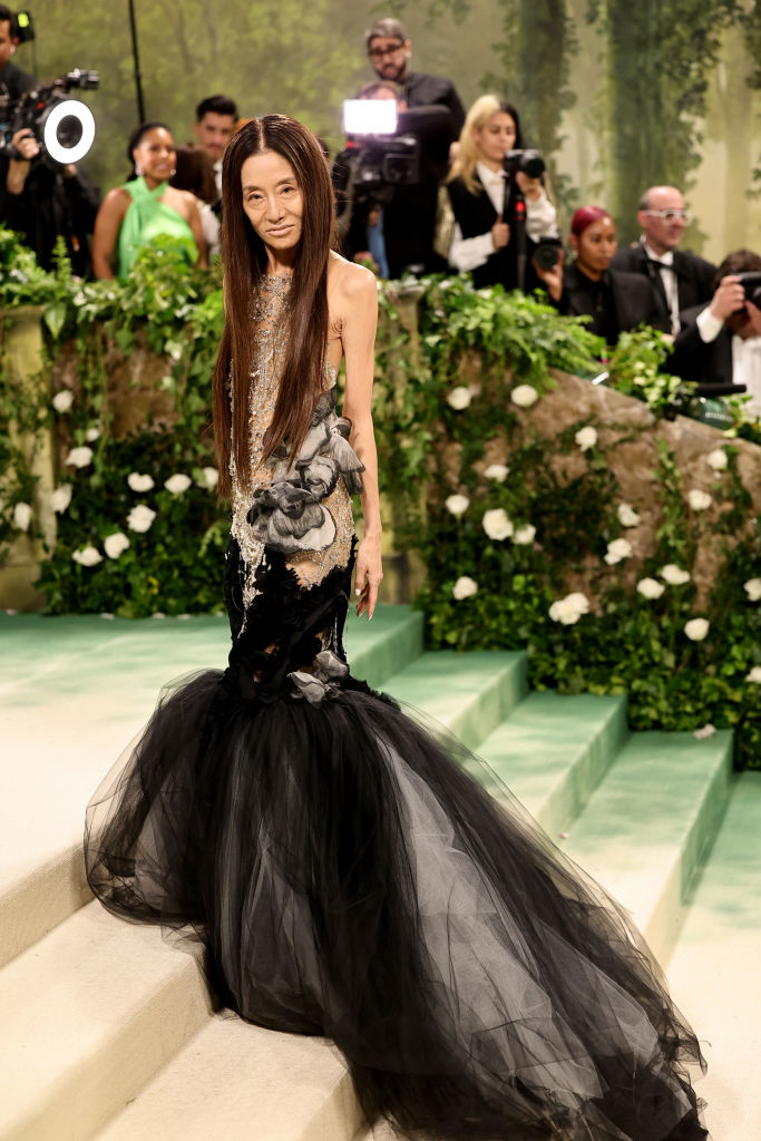 Vera Wang in a black and silver gown at an event with onlookers behind her
