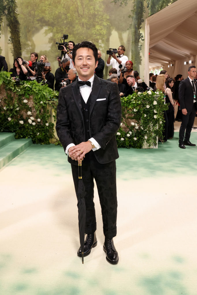 Steven in a velvet suit with bow tie holding an umbrella on the Met Gala carpet