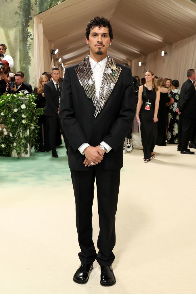 Omar wearing a suit with unique metallic ornamentation with little flowers on the jacket