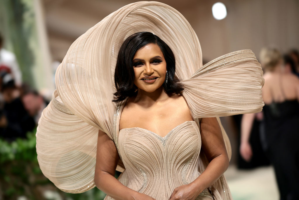 Mindy Kaling wearing a gown with a large, spiraled headpiece
