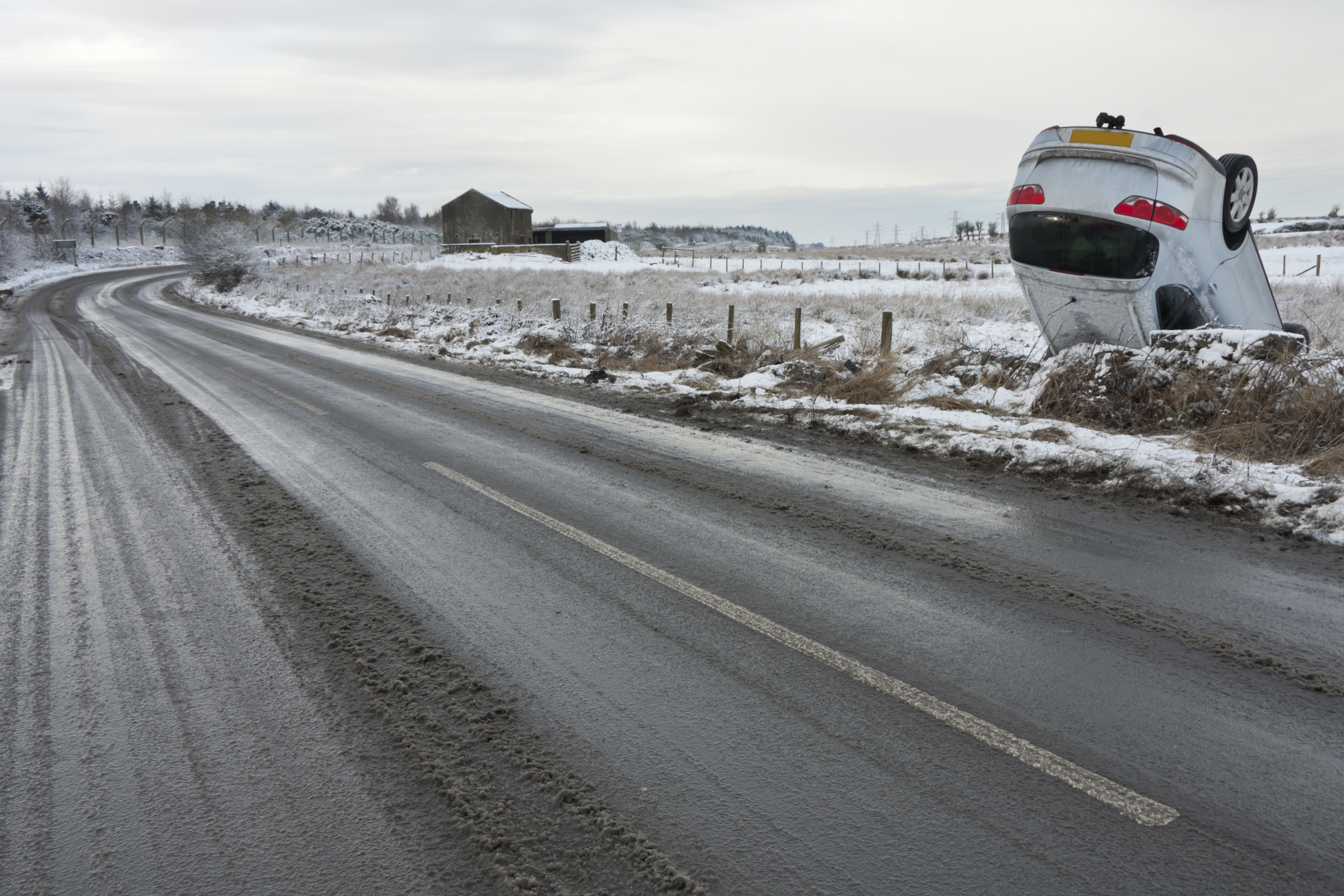Overturned car beside a snowy road
