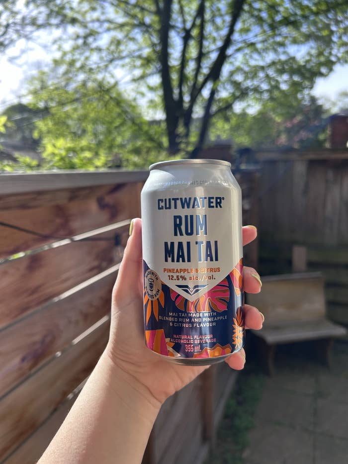 Hand holding a can of Cutwater Rum Mai Tai beverage outdoors