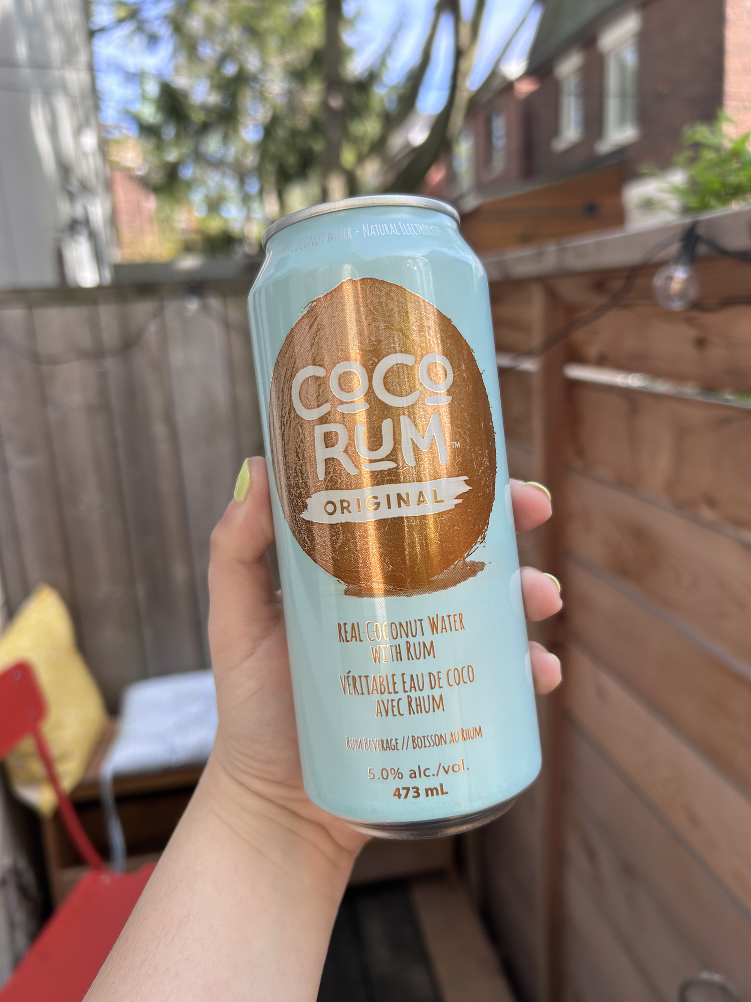 Hand holding a can of Coco Rum Original flavored with real coconut water