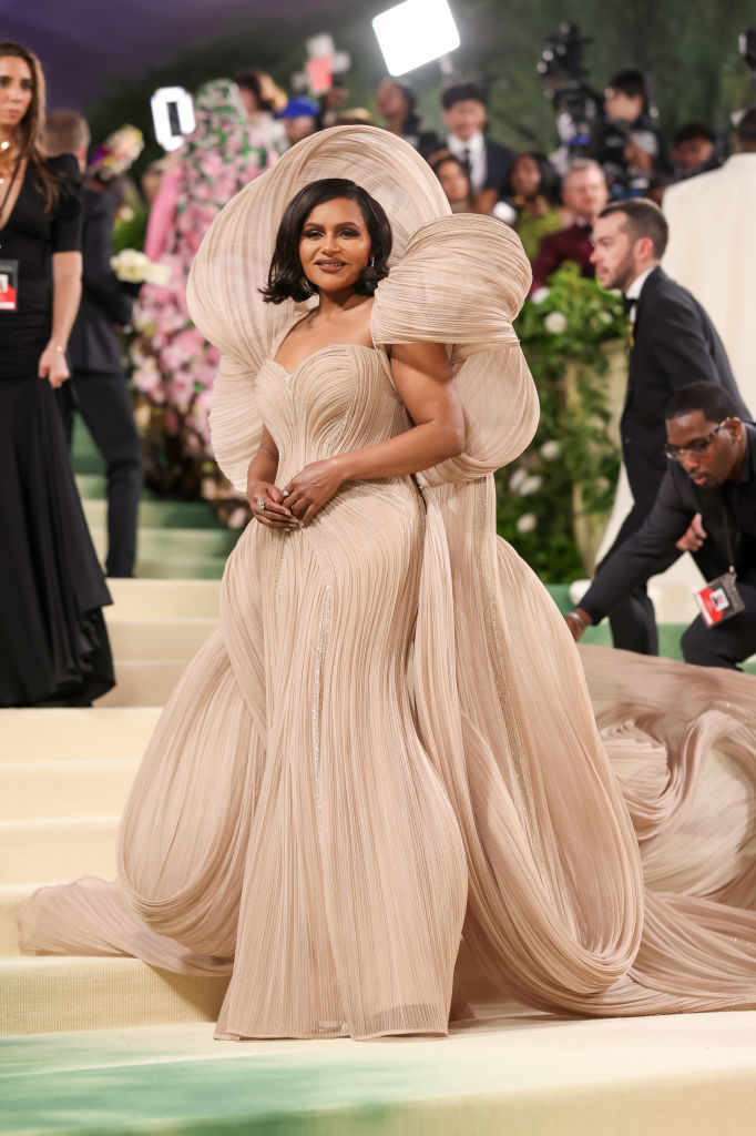 Mindy Kaling wearing an extravagant pleated gown with oversized shoulder detailing at the Met Gala