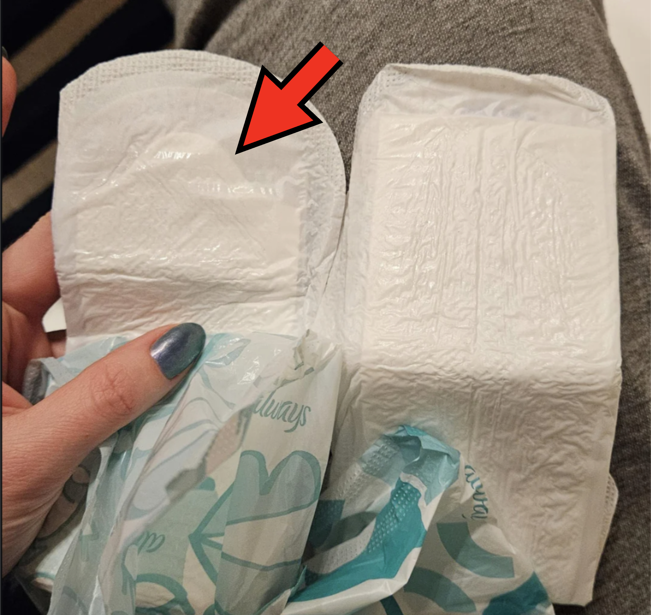 Woman holding two maxi pads, one with much less absorbent filling