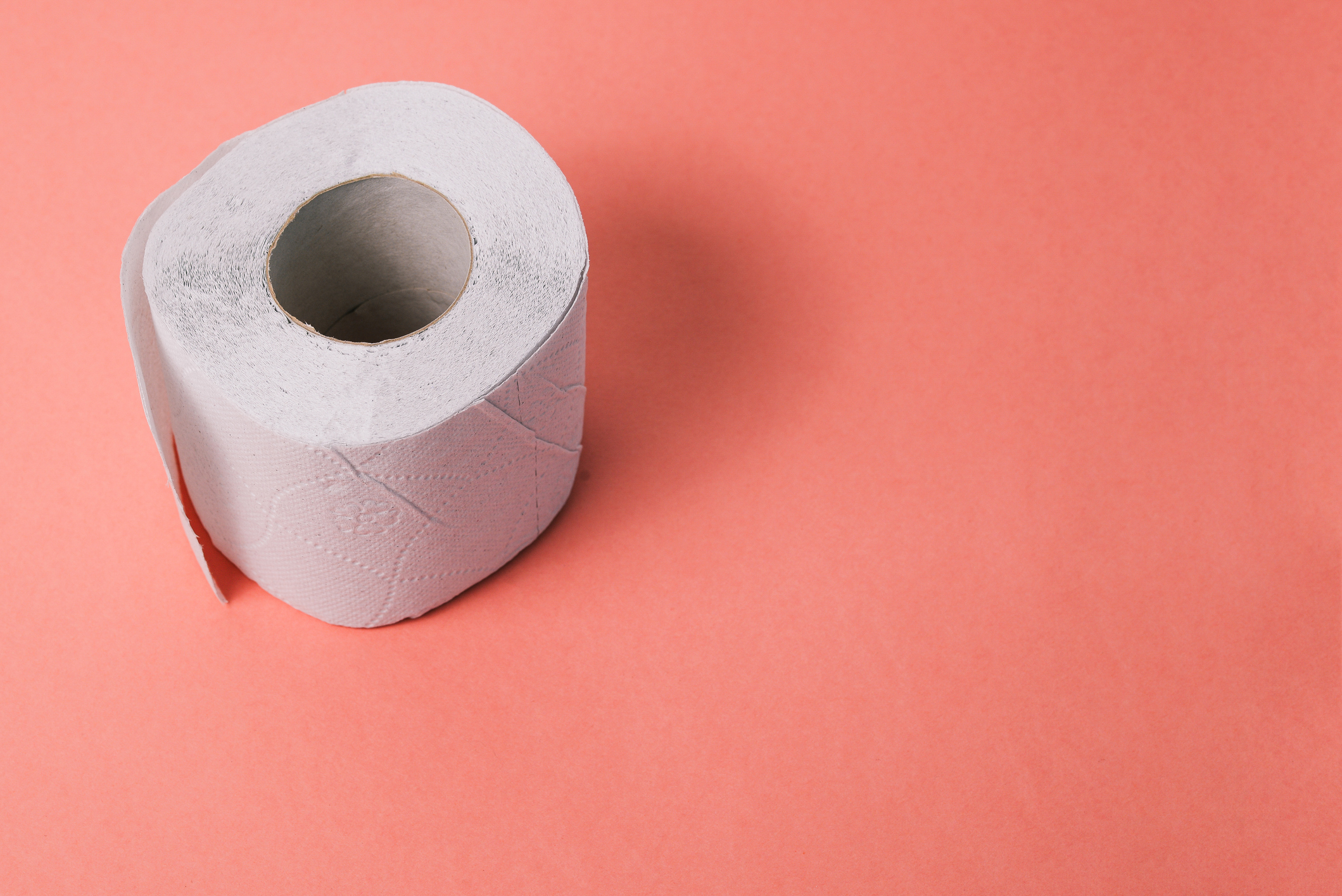 A roll of toilet paper on a plain background