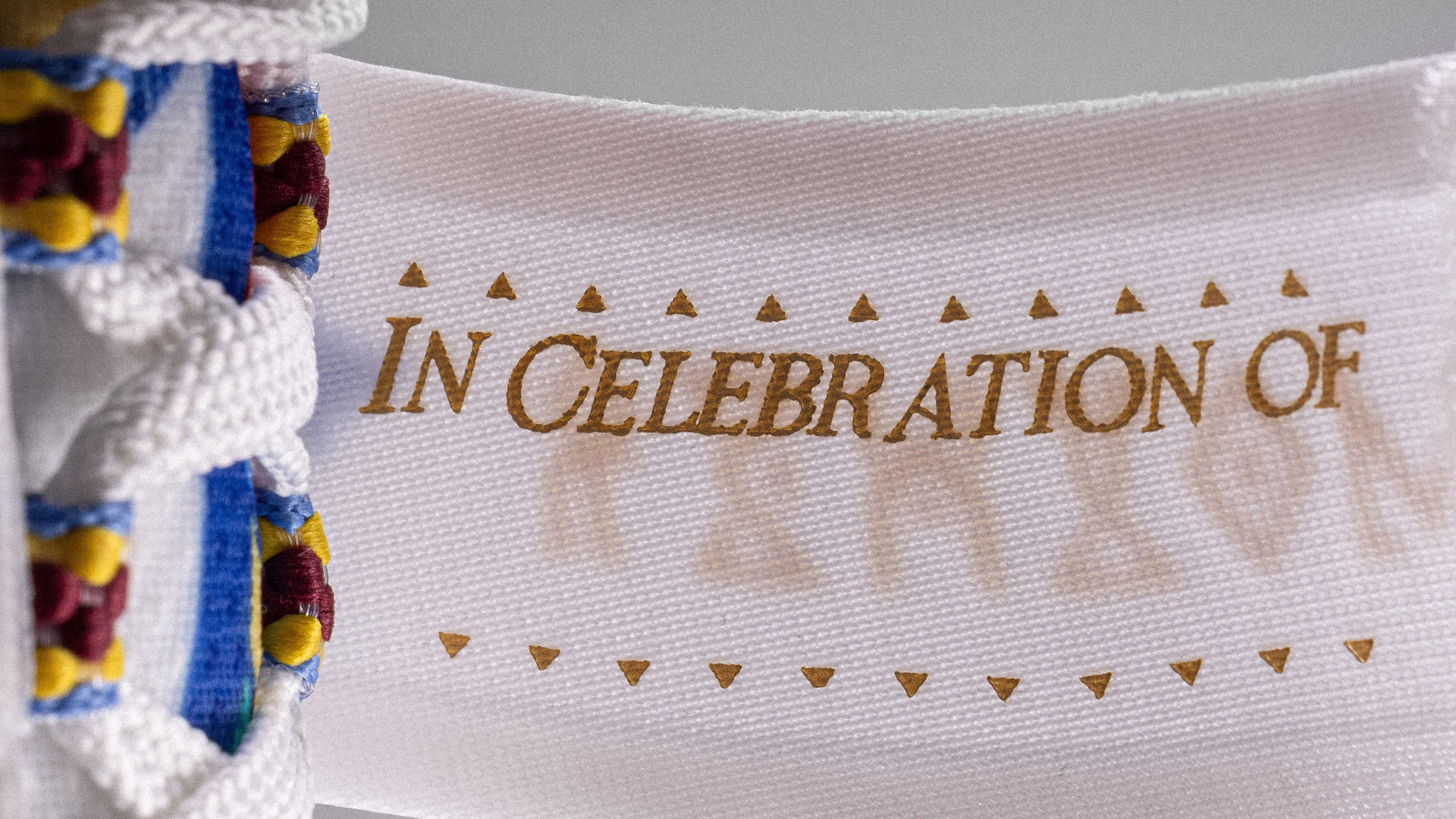 Sneaker close-up with &quot;IN CELEBRATION OF&quot; text and decorative stitching