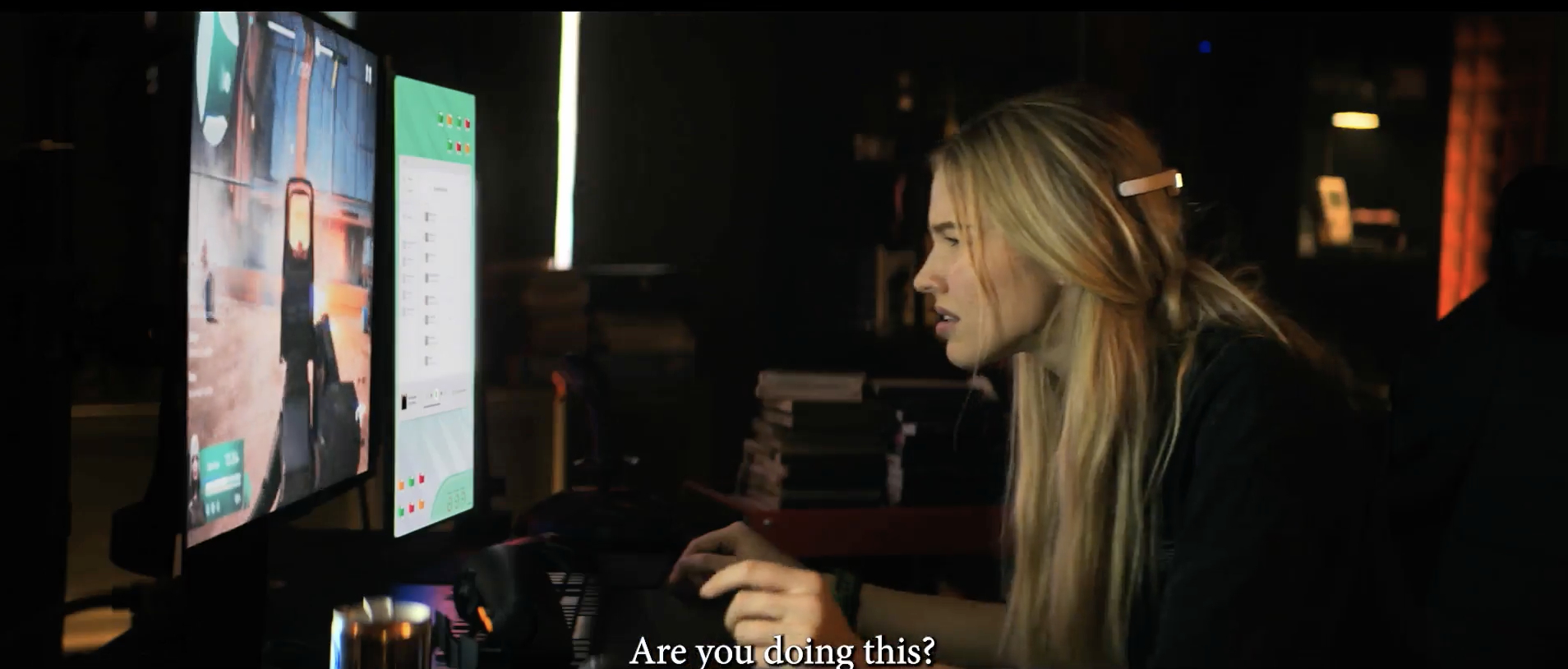 Sasha Luss interacts with computer screens on a set, subtitle reads &quot;Are you doing this?&quot;
