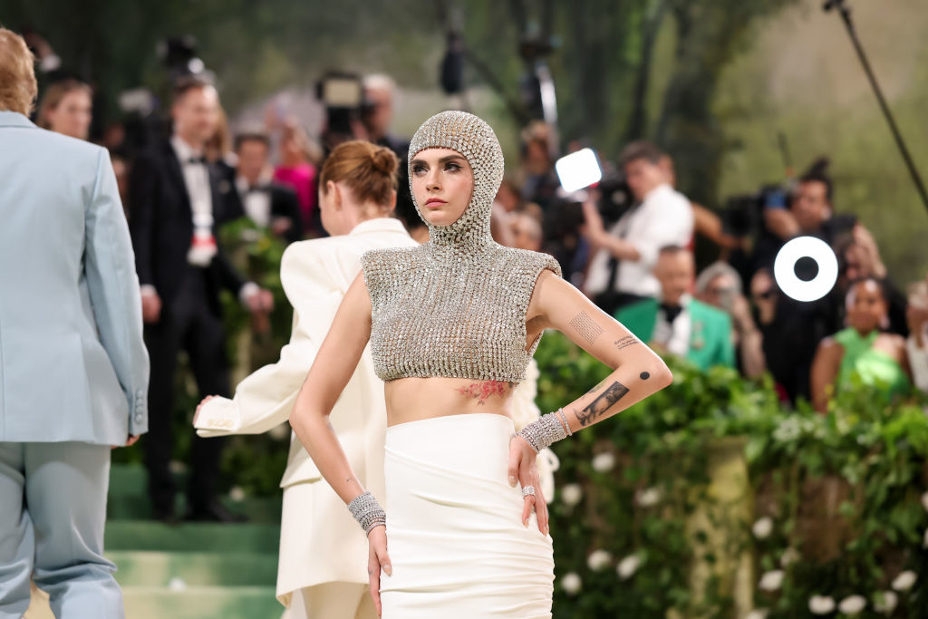 Cara Delevingne in a cropped chainmail top and white skirt at an event