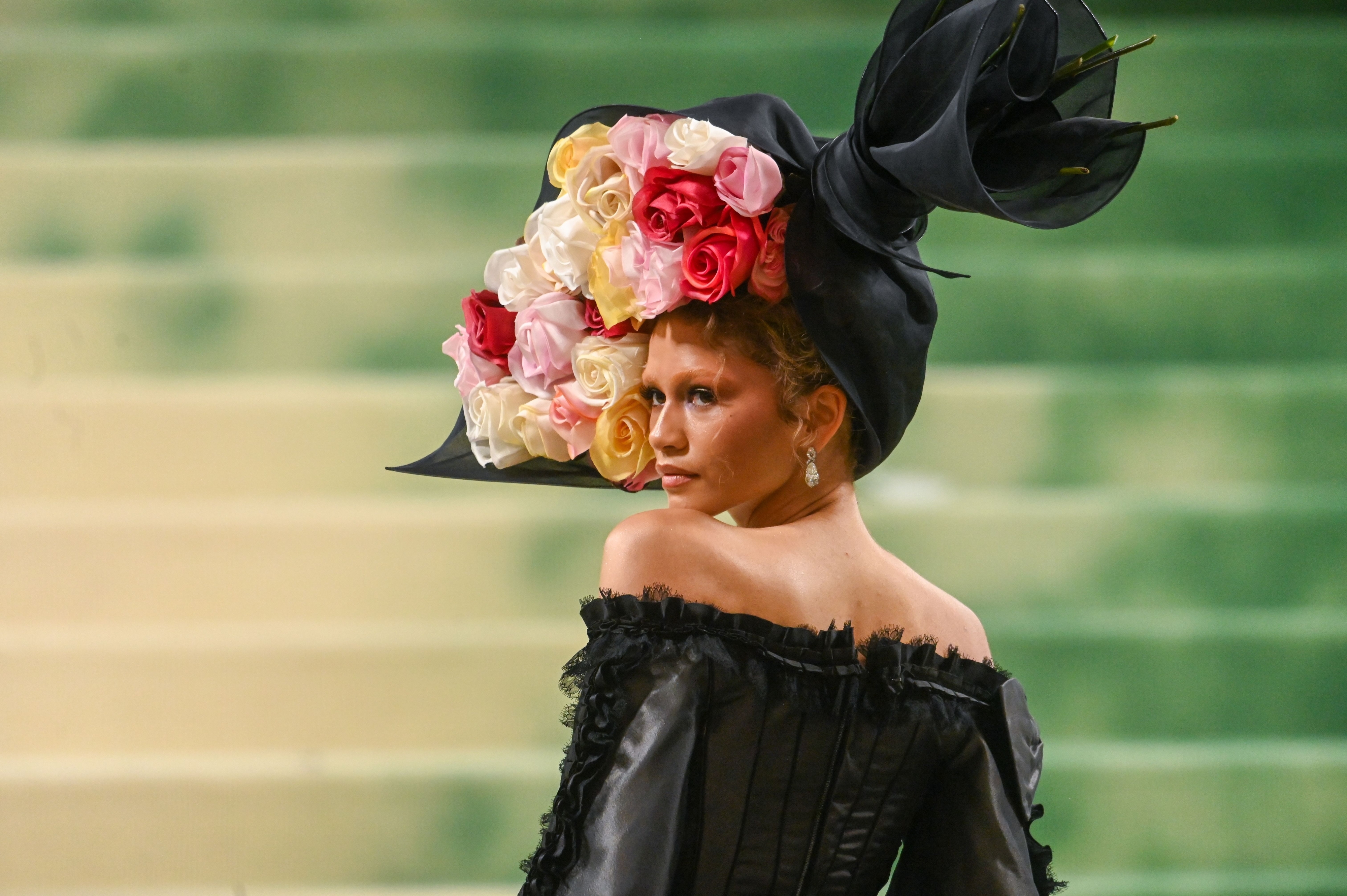 Zendaya in elaborate floral hat and off-shoulder black dress