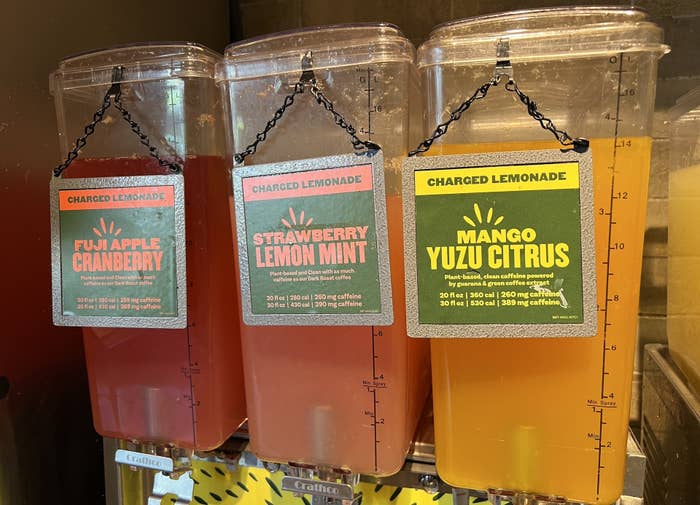 Three containers labeled Charged Lemonade, one each with Fuji Apple Cranberry, Strawberry Lemon Mint, and Mango Yuzu Citrus flavors