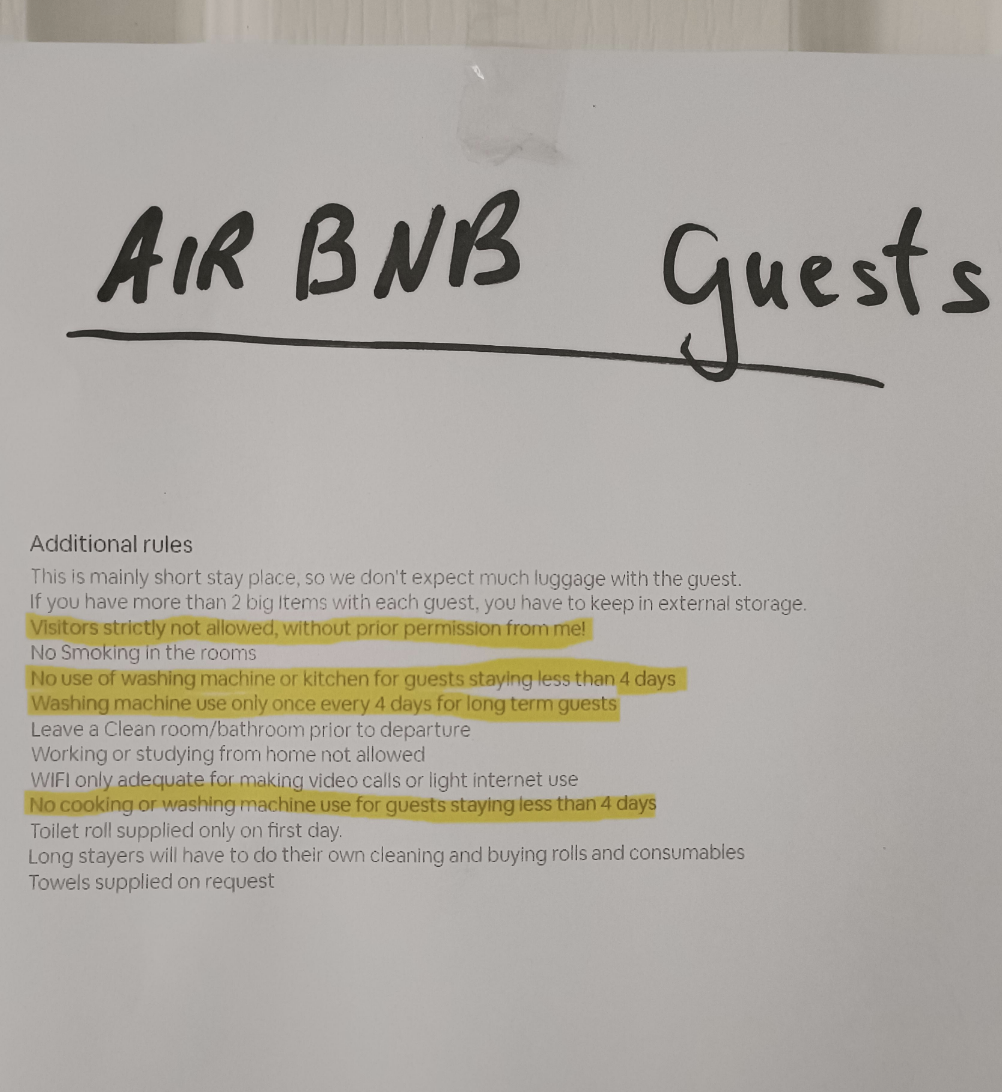 Handwritten Airbnb house rules sign with additional rules listed for guests