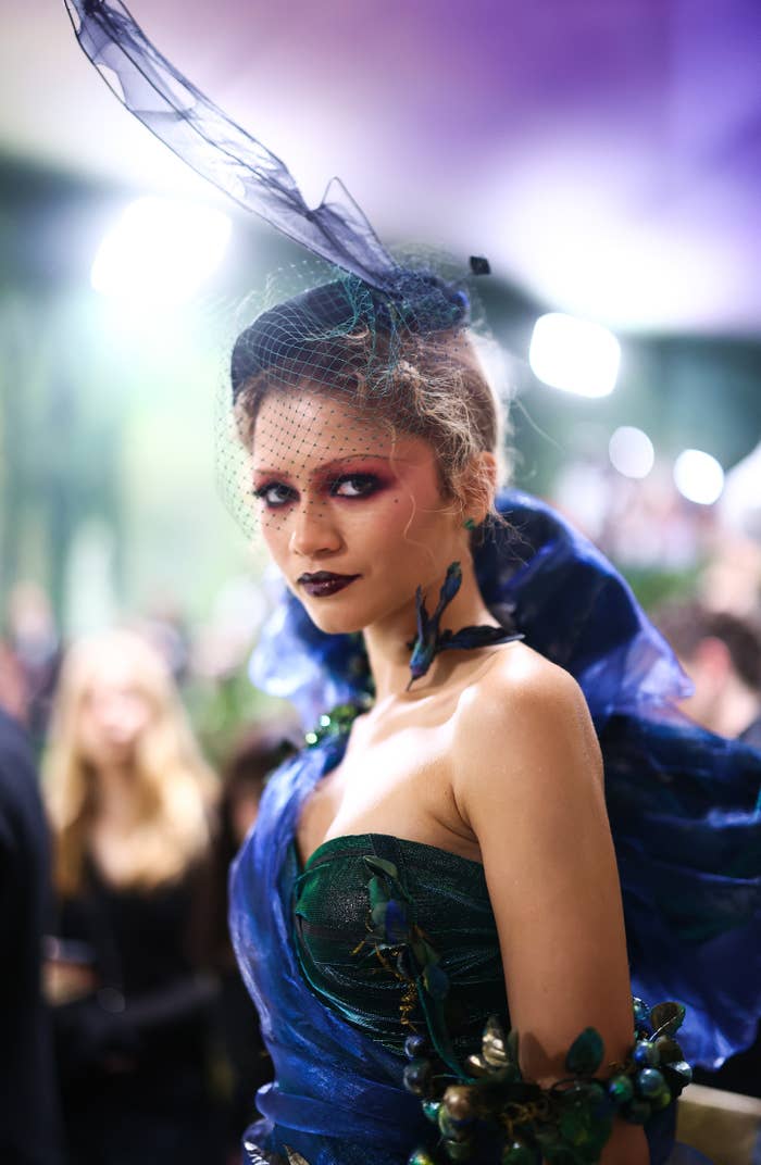 Zendaya in elaborate blue outfit with mesh headpiece at the 2024 Met Gala