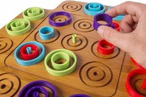 Hand interacting with a wooden educational color sorting and size sequencing toy