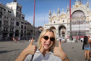 Emma Chamberlain gives a thumbs up in front of the St. Mark's Basilica in Venice