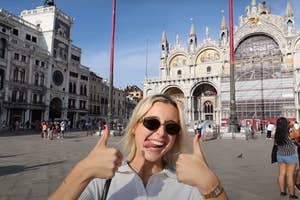 Emma Chamberlain gives a thumbs up in front of the St. Mark's Basilica in Venice