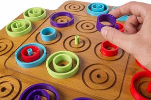 Hand interacting with a wooden educational color sorting and size sequencing toy