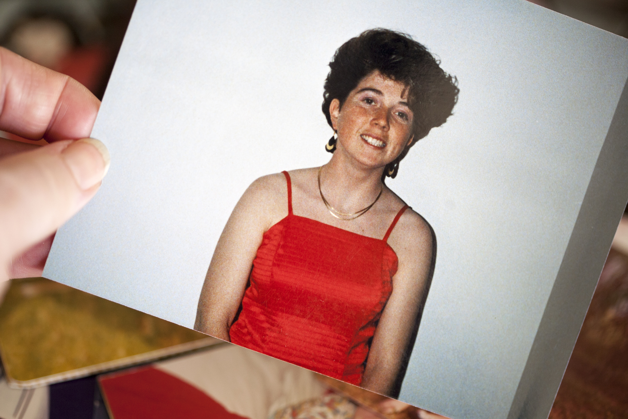 Woman in a sleeveless red dress posing for a photo; part of a series of personal photographs