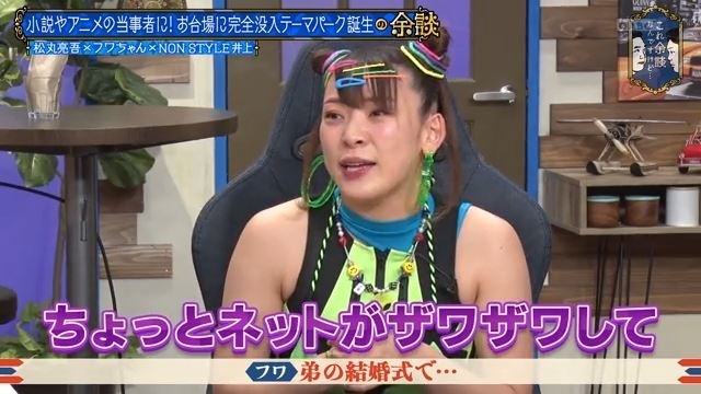 テレビ番組に出演するエンターテイナーがカラフルなアクセサリーを付けて話している様子。