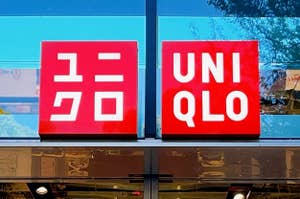 ユニクロ店舗の入り口、ガラス張りのファサードに店名のロゴが掲げられている。