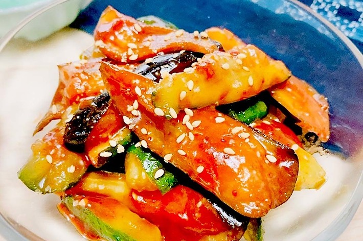 野菜とたれをかけた炒め物が入った透明なボウル。