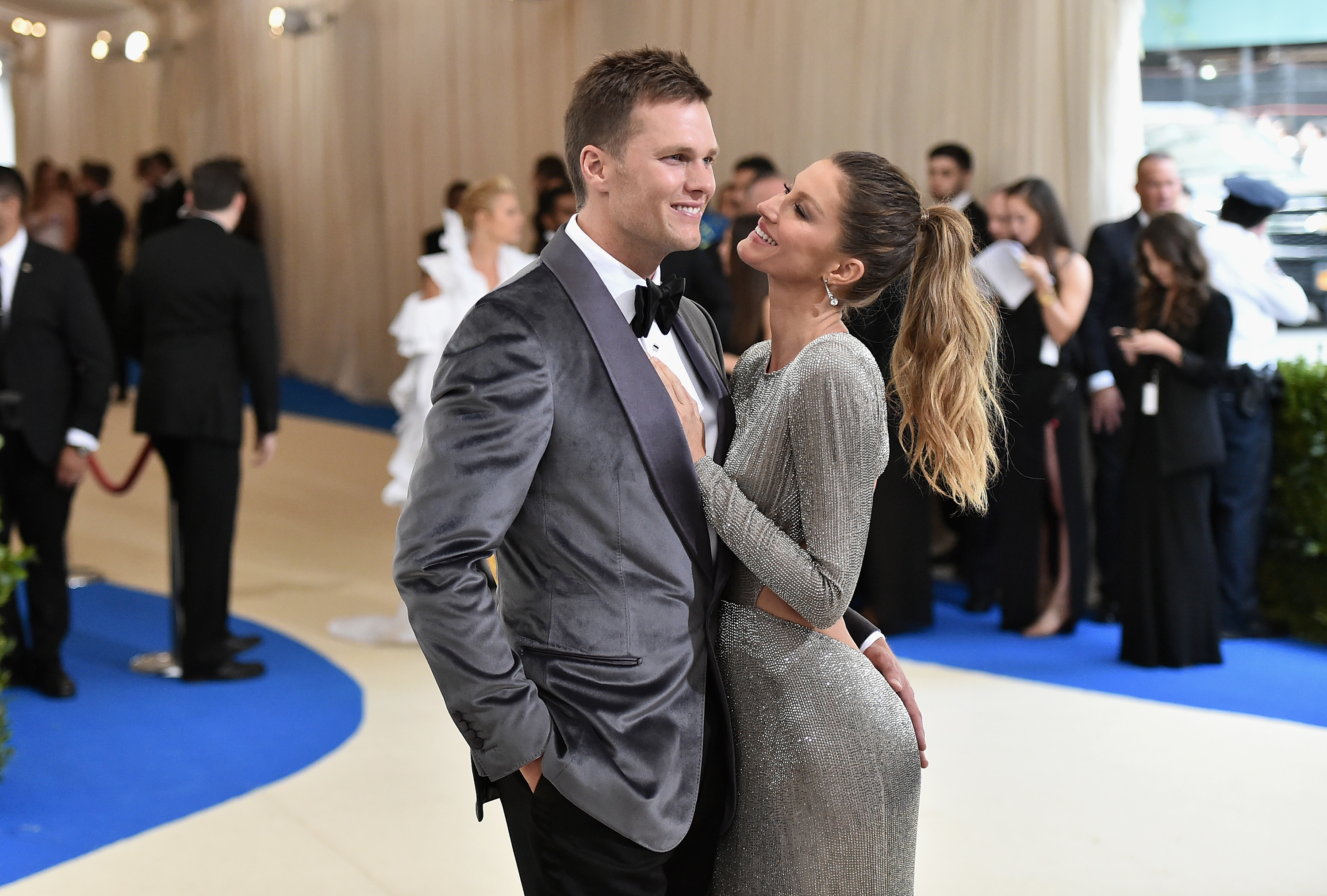 Tom Brady and Gisele Bündchen posing together, he in a tuxedo and she in a shimmering gown