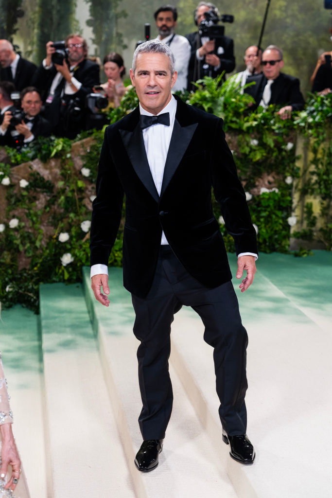 Andy Cohen in a black velvet tuxedo with a bow tie on the red carpet