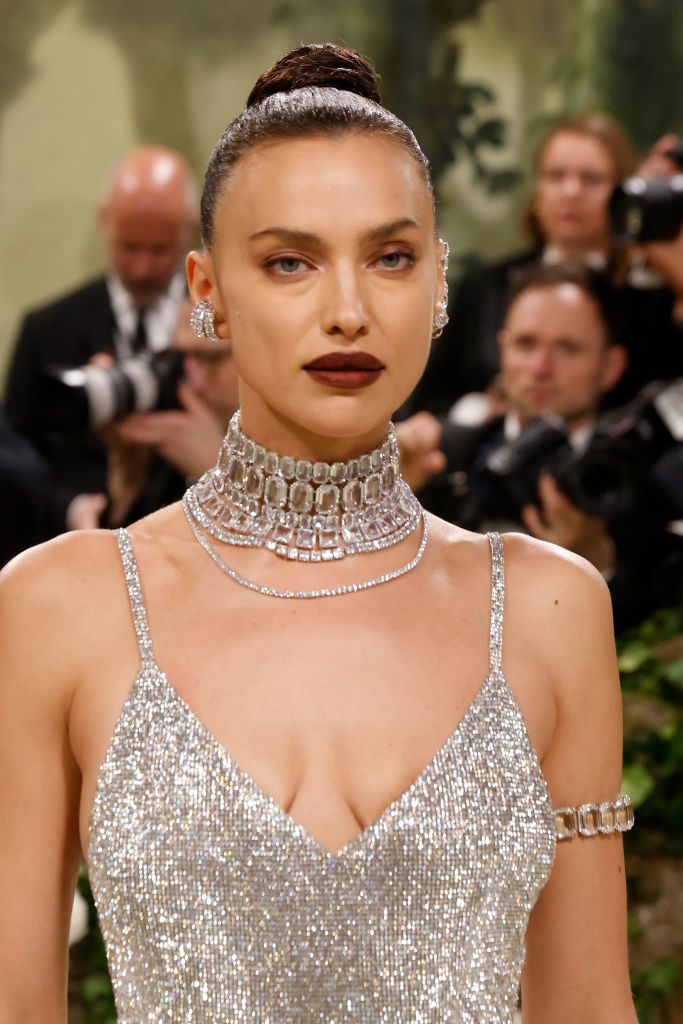 Irina dressed in a glittering outfit with a prominent choker necklace
