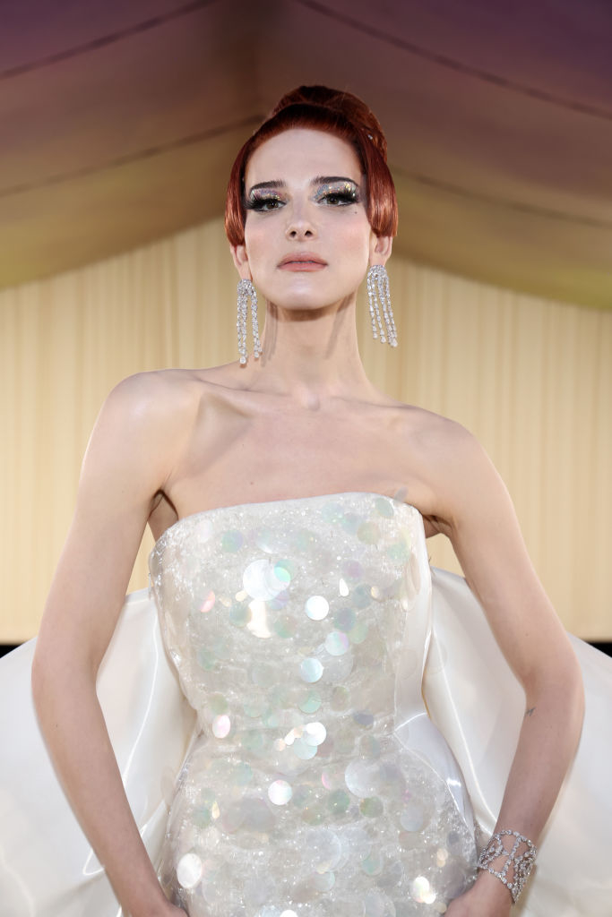 Hari Nef in a strapless gown with shimmering details and long, dangling earrings