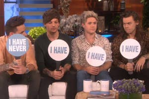 Four members of One Direction holding up signs that say "I HAVE NEVER" and "I HAVE" during a talk show segment
