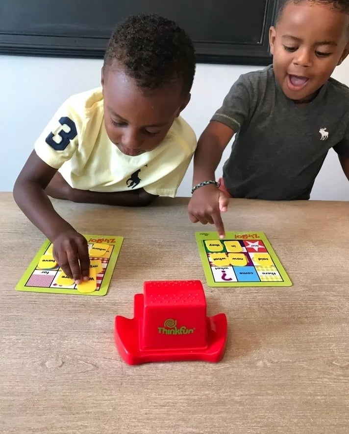 Two child models playing the sight word bingo game