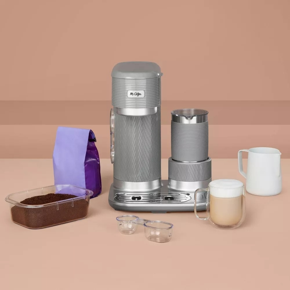 Portable coffee maker with accessories and a cup of coffee displayed on a table