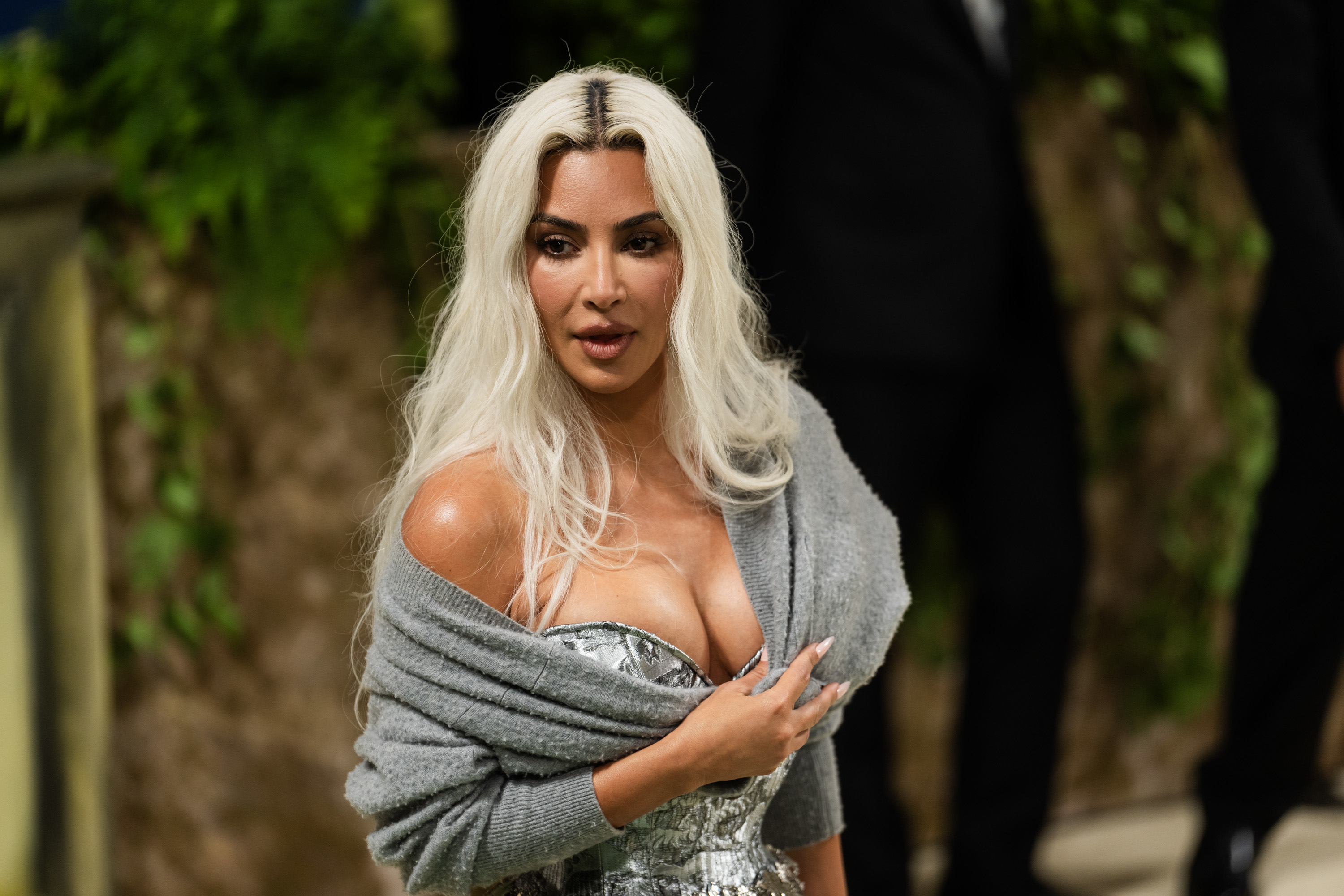 Kim Kardashian wearing a silver dress and grey shawl at an event