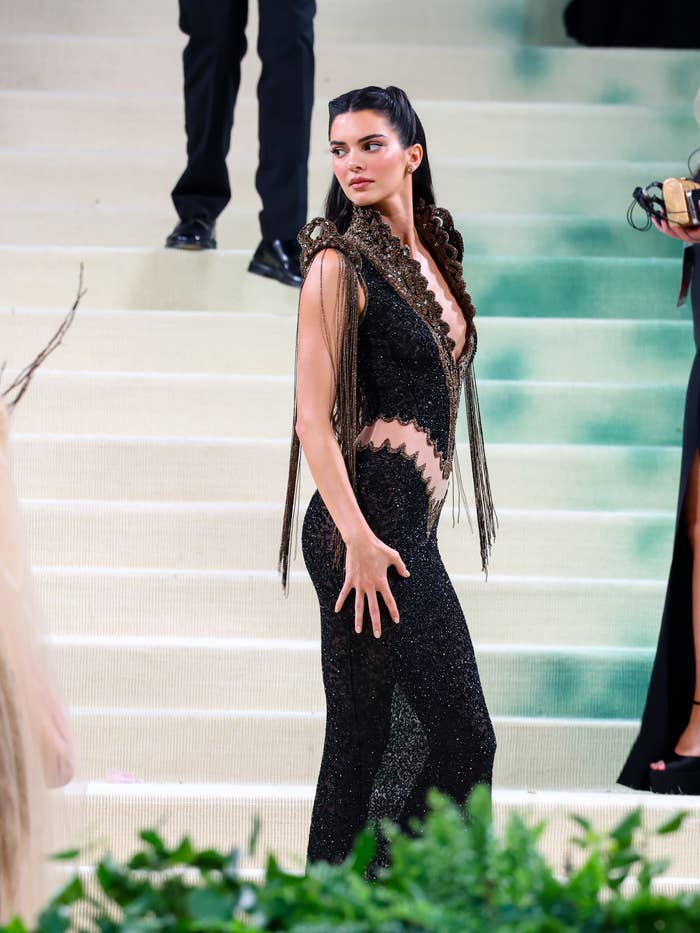 Kendall Jenner in a black cut-out dress with fringe details at an event