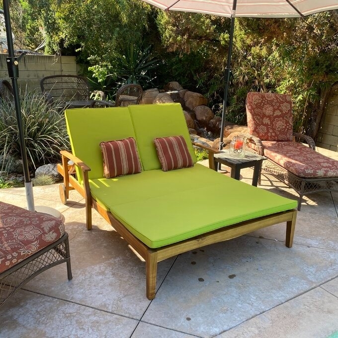 Outdoor furniture set with a green cushioned lounge chair and a patio umbrella, ideal for a garden setting