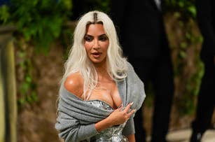 Kim Kardashian in a metallic dress with a gray wrap at an event