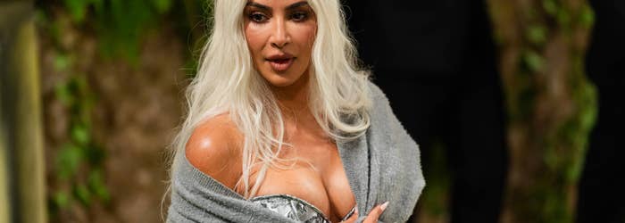 Kim Kardashian in a metallic dress with a gray wrap at an event