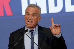 Man gesturing while speaking at a podium with a "Talk Middle" backdrop
