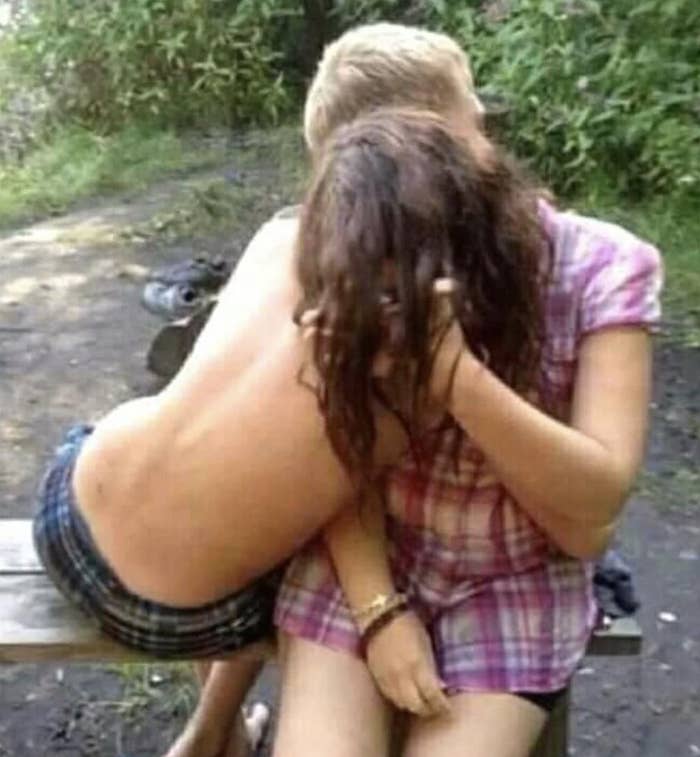 A couple embracing on a bench, the person has a shirtless back