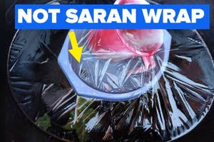 A frozen flower displayed in a clear ice bowl with "NOT SARAN WRAP" text and a yellow arrow pointing at the ice