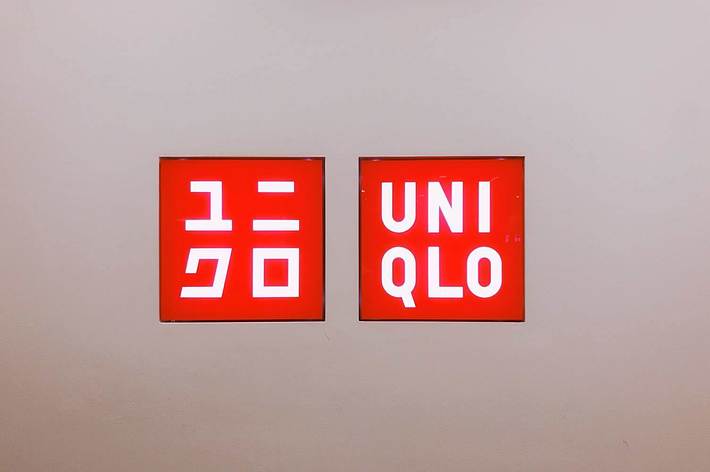 ユニクロのロゴが書かれた二つの看板が壁に掛けられている。
