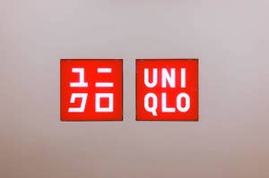 ユニクロのロゴが書かれた二つの看板が壁に掛けられている。